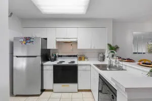 a kitchen with a sink a refrigerator and white cabinets