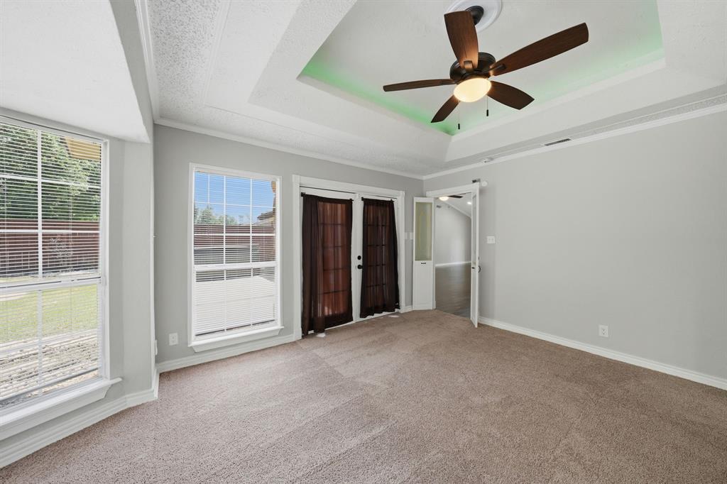 1108 Billie Ruth Lane Hurst, TX 76053 - Photo 13 of 27 Carpeted room with a tray ceiling featuring a ceiling fan with integrated lighting