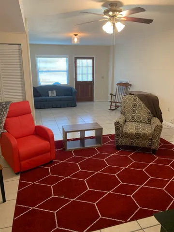 a living room with patio furniture and a chandelier