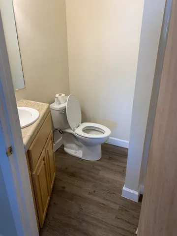 a white toilet sitting next to a sink and vanity