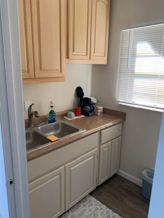 a kitchen with stainless steel appliances granite countertop white cabinets a sink and dishwasher with wooden floor