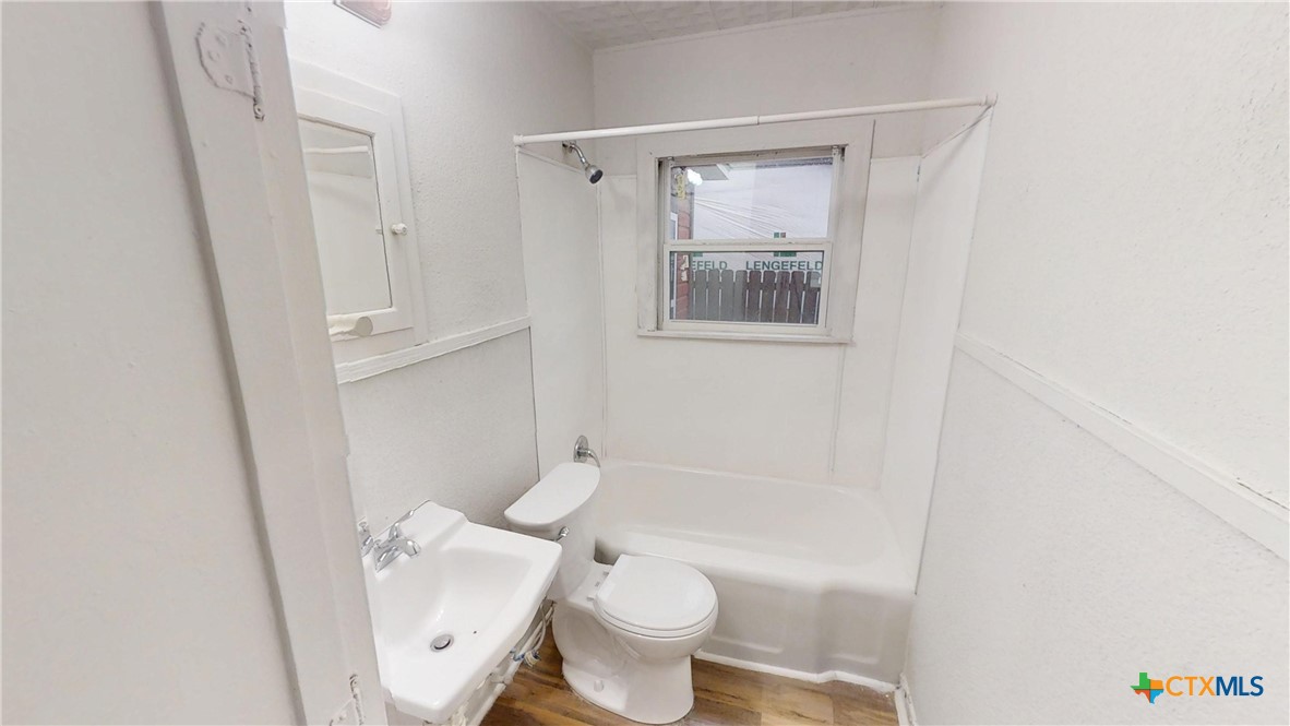 1114 South 2nd Street Temple, TX 76504 - Photo 11 of 13 a white toilet sitting next to a bathroom sink