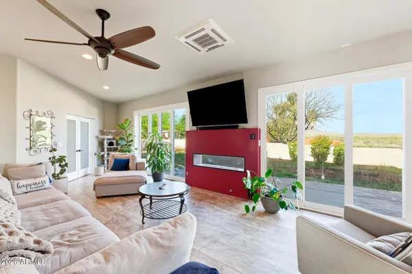 a living room with furniture a flat screen tv and a large window