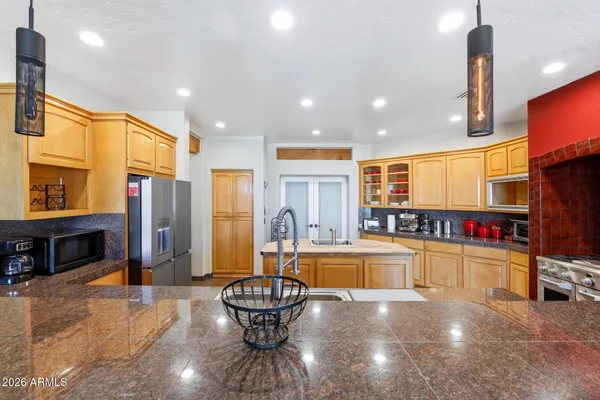 a kitchen with stainless steel appliances granite countertop a refrigerator and a sink