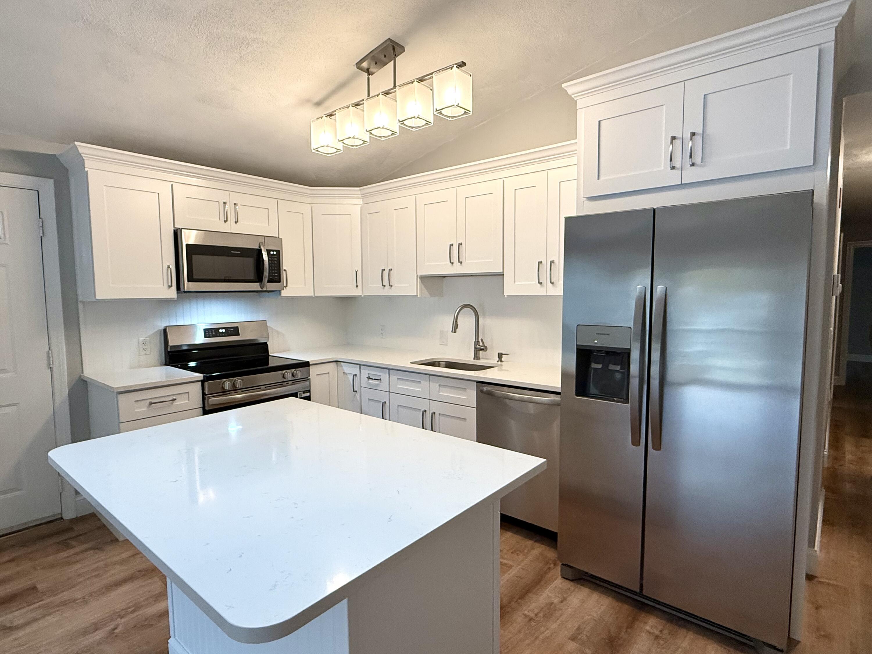 70 Cape Drive, Unit 4C Mashpee, MA 02649 - Photo 2 of 6 a kitchen with granite countertop a refrigerator and a stove top oven