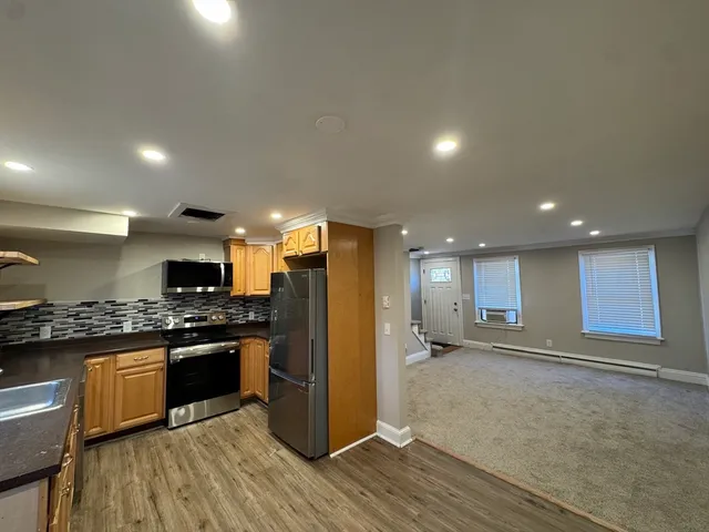 a kitchen with stainless steel appliances granite countertop a refrigerator a stove a sink and a oven