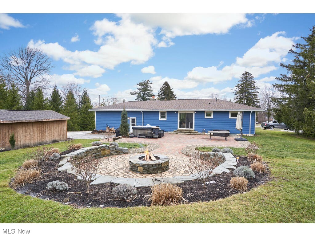 11530 Girdled Road Painesville, OH 44077 - Photo 23 of 32 Rear view of house featuring a fire pit, a yard, and a patio area