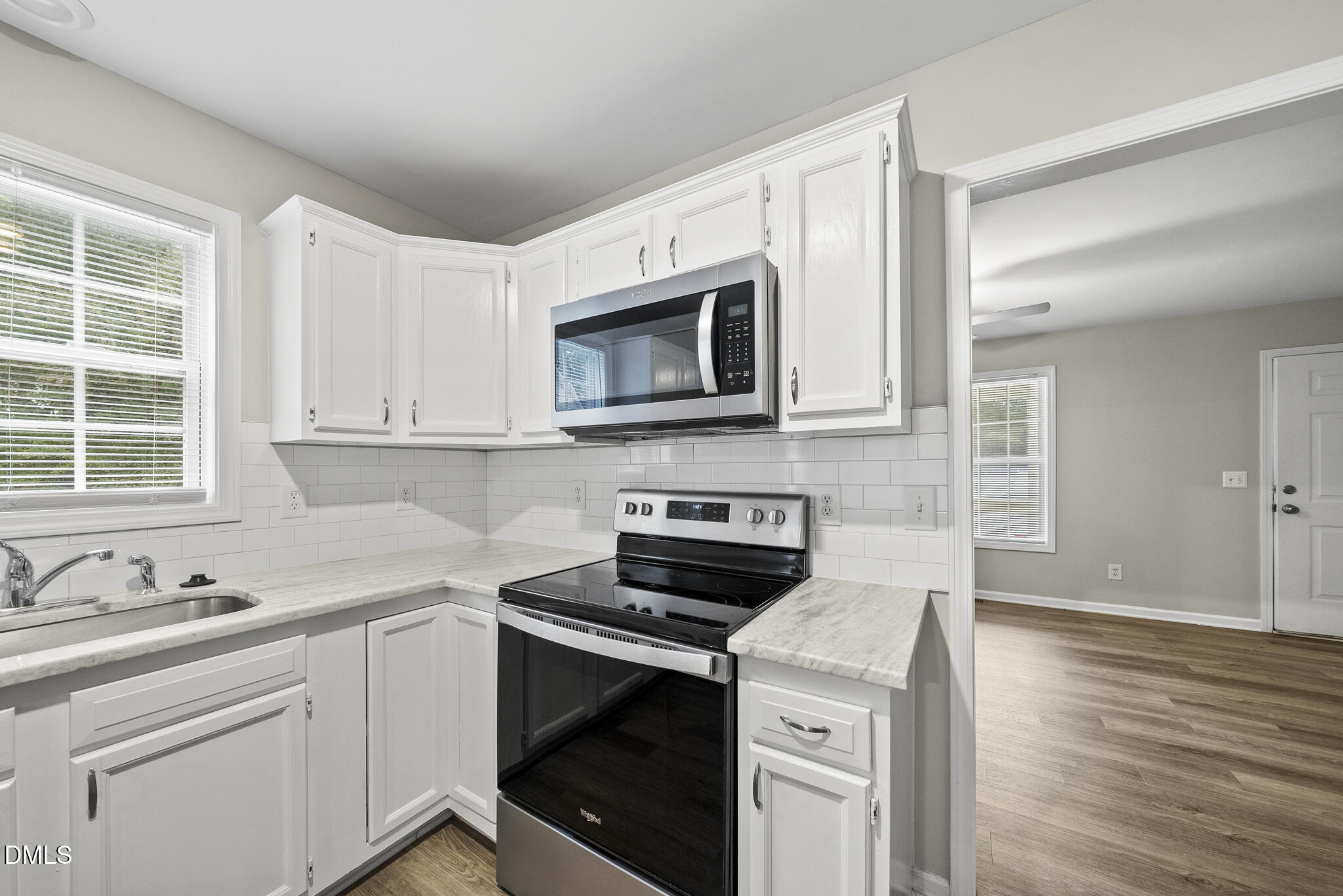 201 Tonylee Court, Unit B Raleigh, NC 27603 - Photo 11 of 29 a kitchen with cabinets stainless steel appliances a sink and wooden floor
