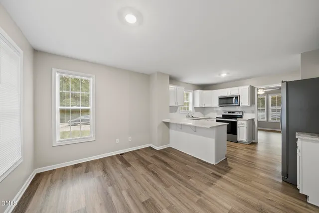 a kitchen with a refrigerator and a stove top oven