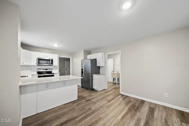 a kitchen with a refrigerator and a stove top oven