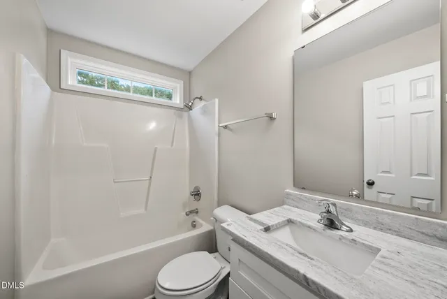 a bathroom with a granite countertop sink toilet a shower and a mirror