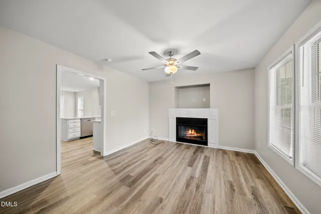 wooden floor fireplace and windows in an empty room
