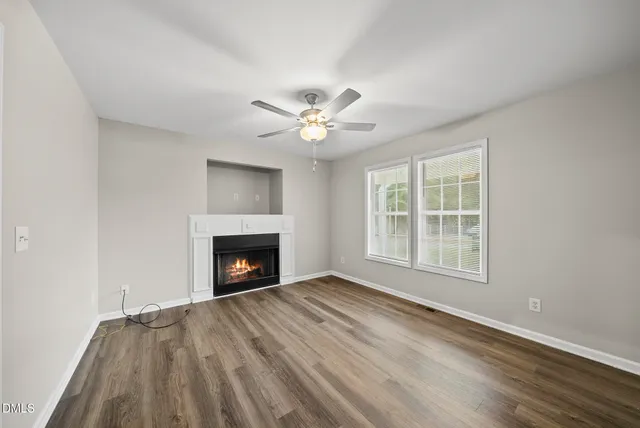 wooden floor fireplace and windows in an empty room