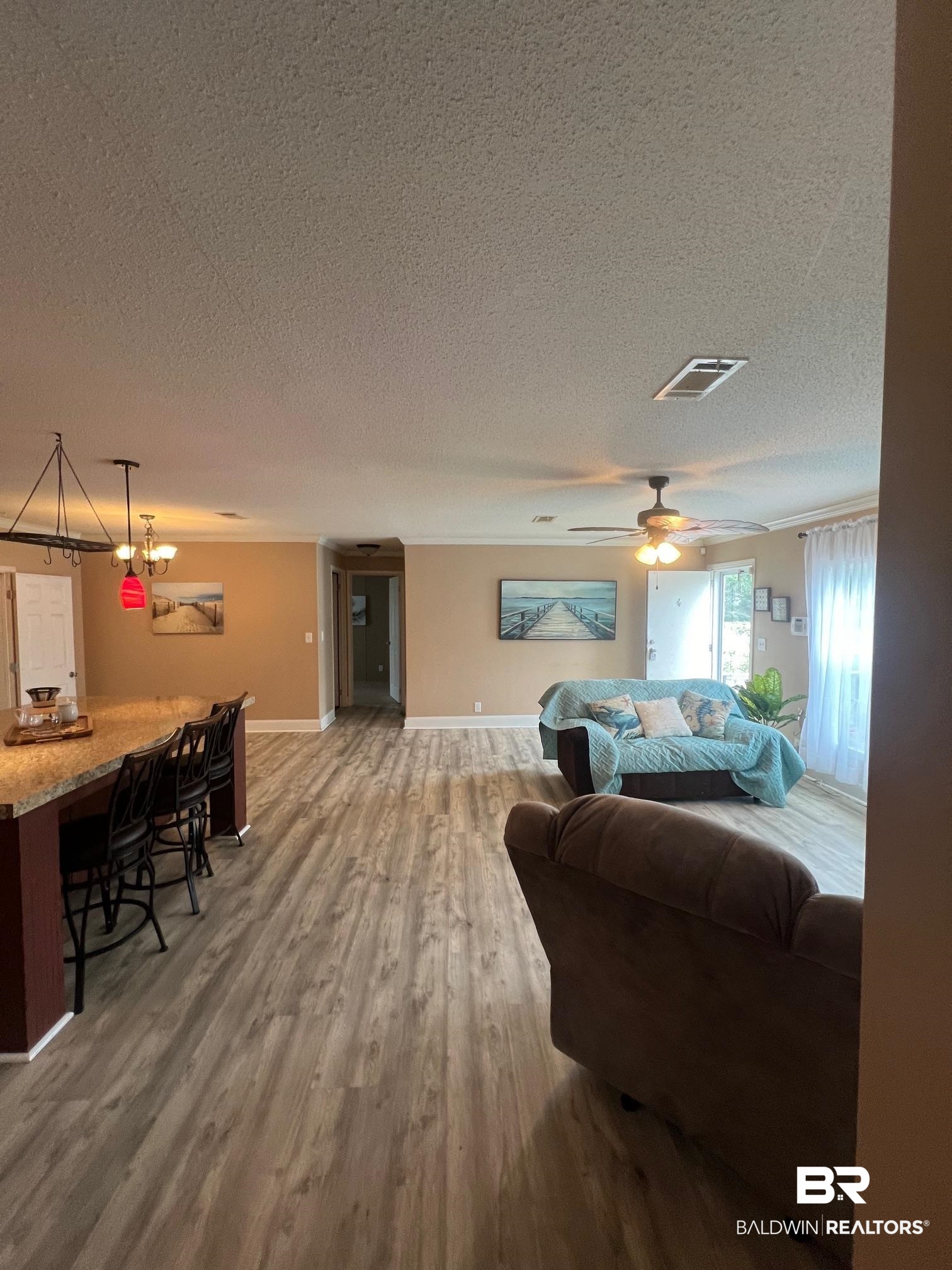 1985 Ridgewood Drive South Lillian, AL 36549 - Photo 5 of 40 Living room with a textured ceiling, ceiling fan, and hardwood / wood-style floors