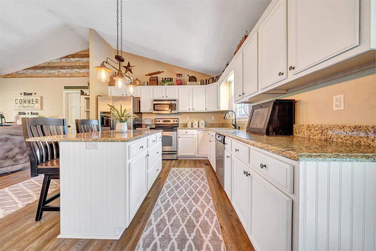 2947 Sandy Level Road Goodview, VA 24095 - Photo 16 of 73 a large kitchen with stainless steel appliances granite countertop a lot of counter space and wooden floors