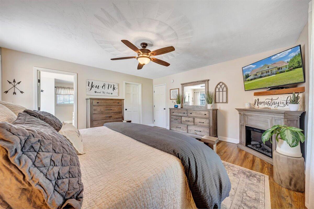 2947 Sandy Level Road Goodview, VA 24095 - Photo 23 of 73 a spacious bedroom with a bed a fireplace and a flat screen tv