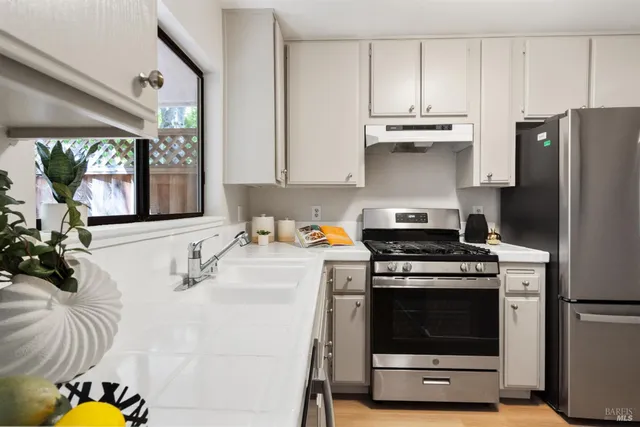 a kitchen with stainless steel appliances a stove a sink and a refrigerator