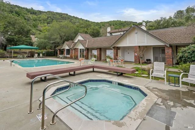 a view of a house with pool and chairs