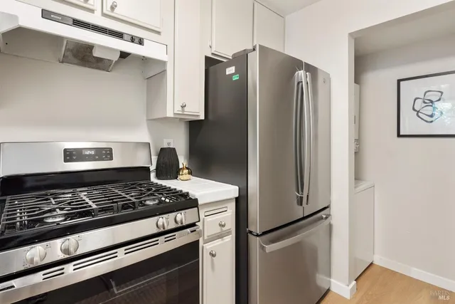 a kitchen with stainless steel appliances granite countertop a refrigerator and a stove