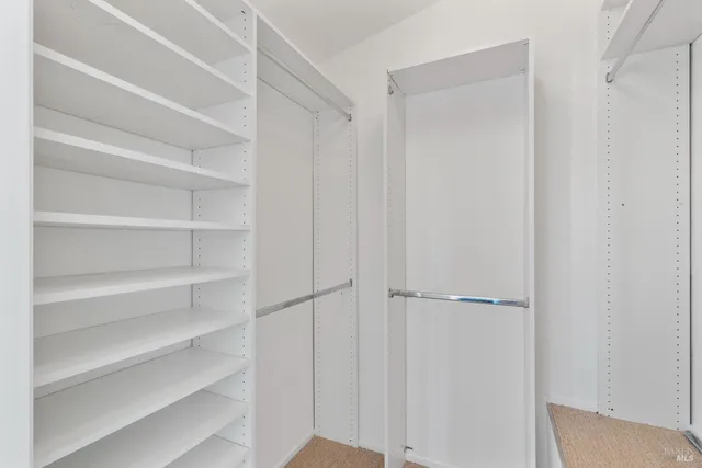 a view of walk in closet with empty racks