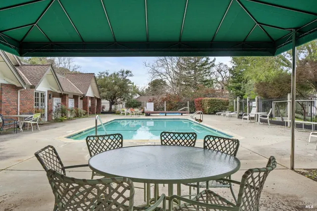 a view of a patio with a table chairs and a umbrella