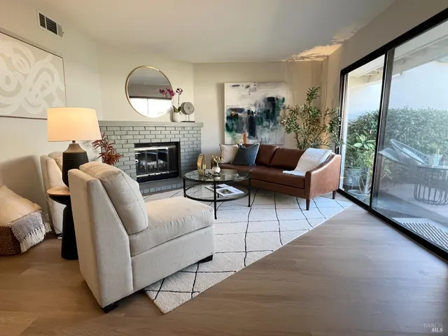a living room with furniture a fireplace and a floor to ceiling window