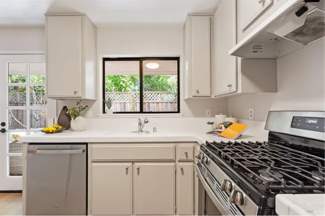 a kitchen with a sink stove top oven and cabinets