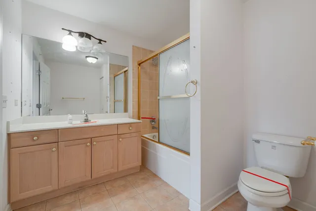 a spacious bathroom with a granite countertop sink a toilet and a mirror