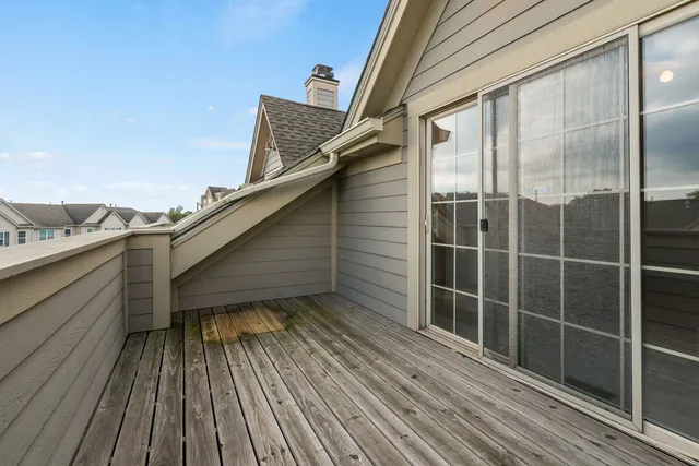 a view of a balcony with wooden floor and fence