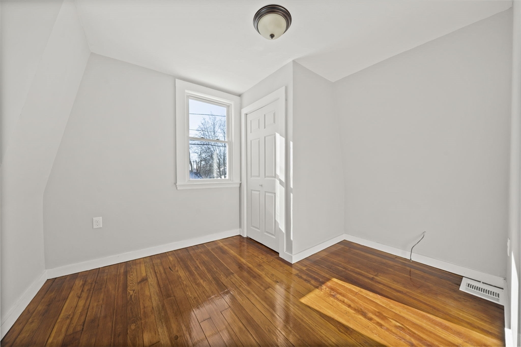 106 Darrow Street Quincy, MA 02169 - Photo 13 of 23 an empty room with wooden floor and windows