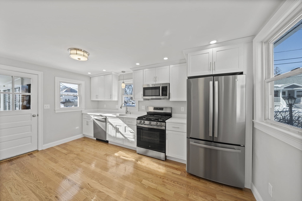 106 Darrow Street Quincy, MA 02169 - Photo 4 of 23 a kitchen with a refrigerator a stove top oven a sink and dishwasher