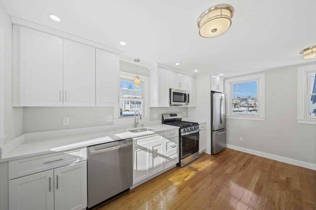 106 Darrow Street Quincy, MA 02169 - Photo 5 of 23 a kitchen with stainless steel appliances white cabinets and a sink