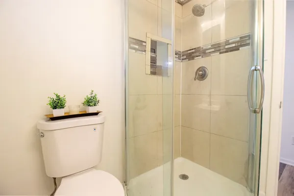 a bathroom with a shower a toilet and a sink