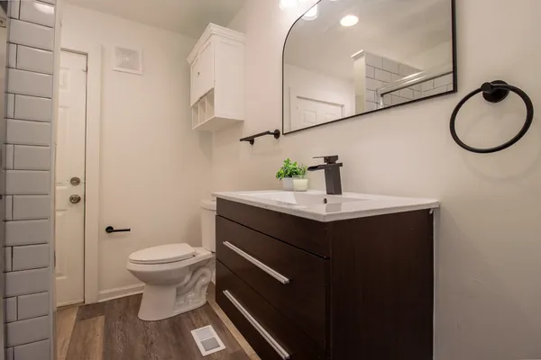 a bathroom with a sink toilet and a mirror