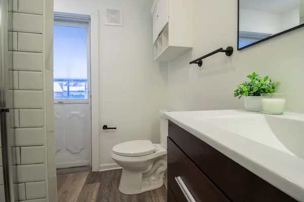 a bathroom with a sink a toilet and shower