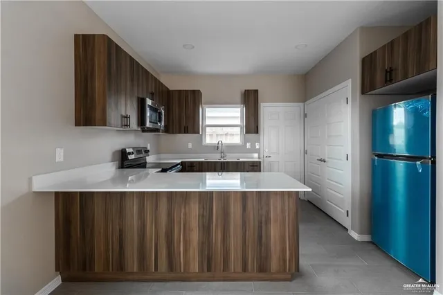 a kitchen with stainless steel appliances granite countertop a refrigerator a sink and a stove