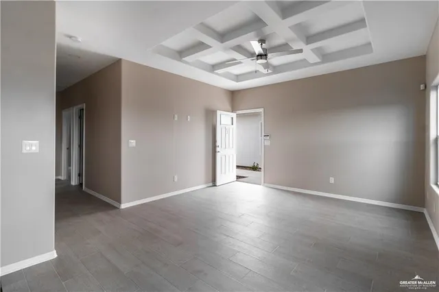 an empty room with a chandelier fan and glass door