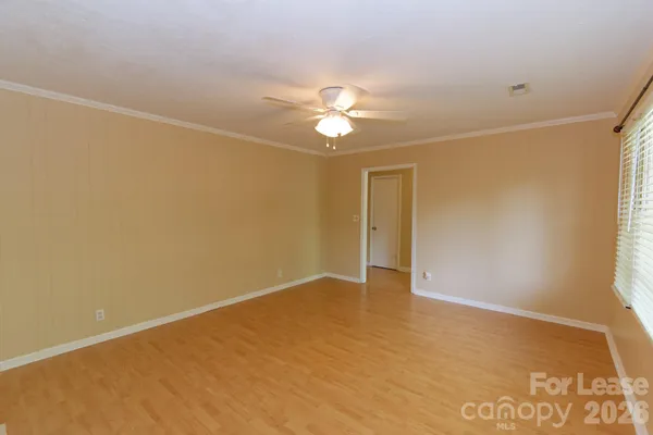an empty room with a ceiling fan and a window