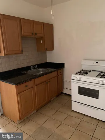 a kitchen with granite countertop cabinets and white stove