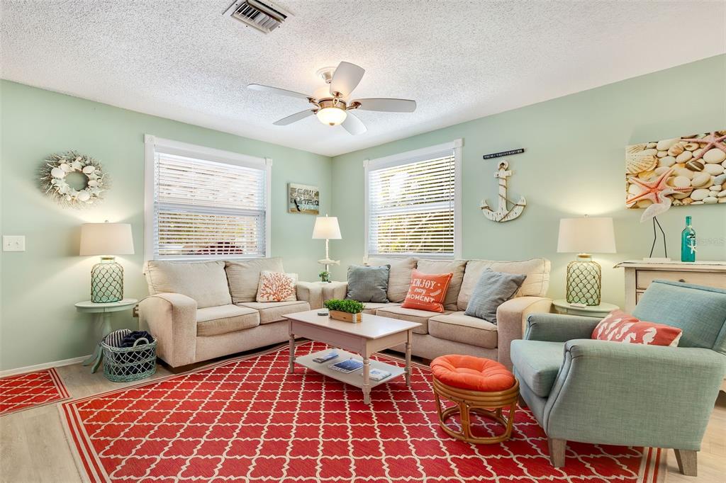 412 80th Street Holmes Beach, FL 34217 - Photo 12 of 58 a living room with furniture a chandelier and a window
