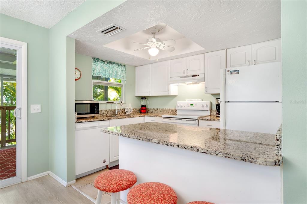 412 80th Street Holmes Beach, FL 34217 - Photo 20 of 58 a kitchen with a refrigerator a sink and a stove