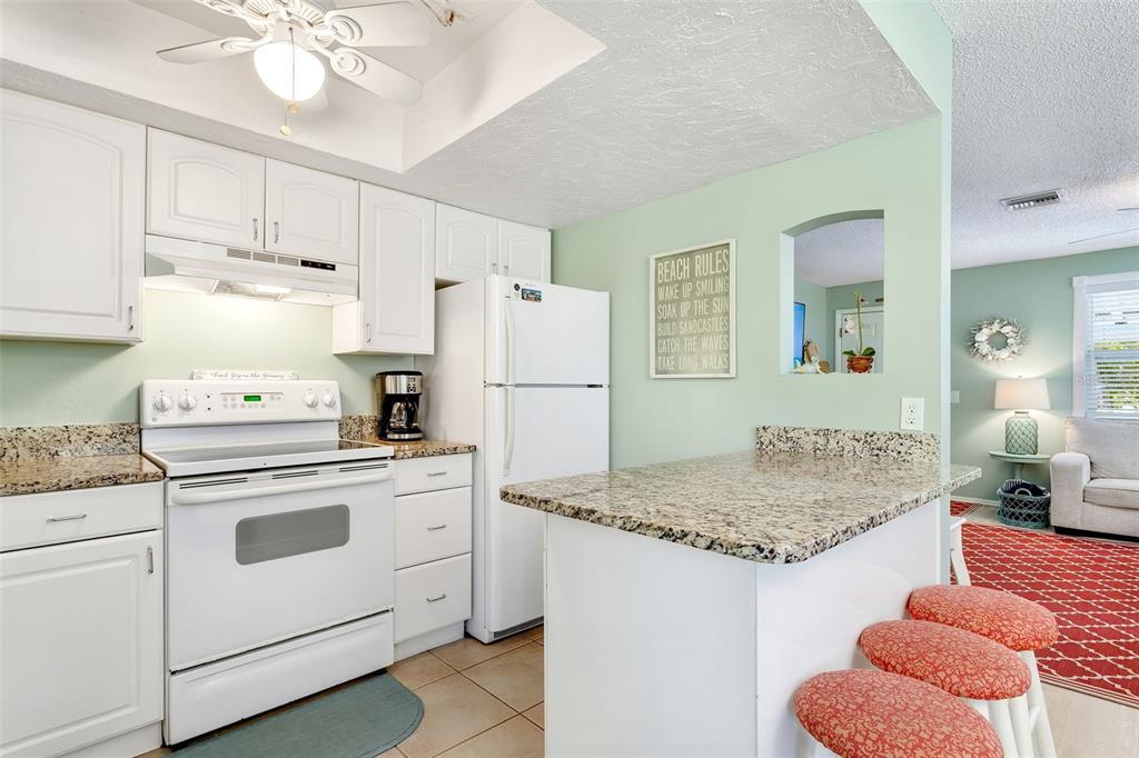 412 80th Street Holmes Beach, FL 34217 - Photo 22 of 58 a kitchen with stainless steel appliances granite countertop a sink stove and refrigerator