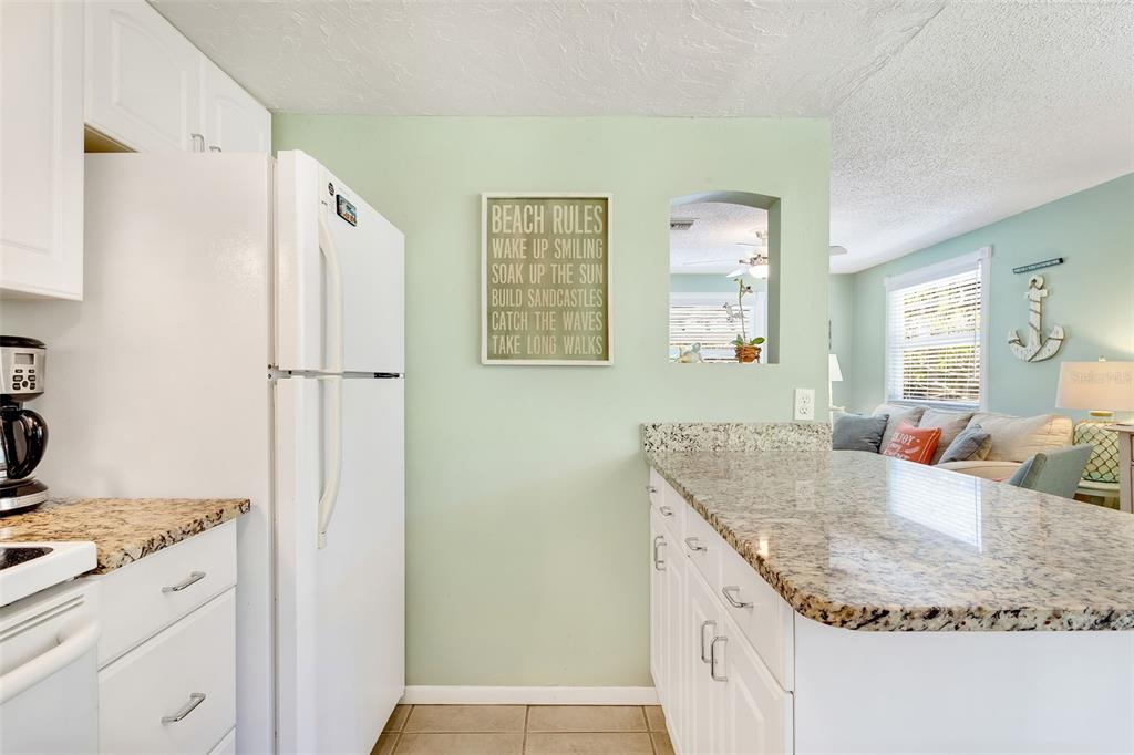 412 80th Street Holmes Beach, FL 34217 - Photo 23 of 58 a kitchen with granite countertop a sink stove and refrigerator