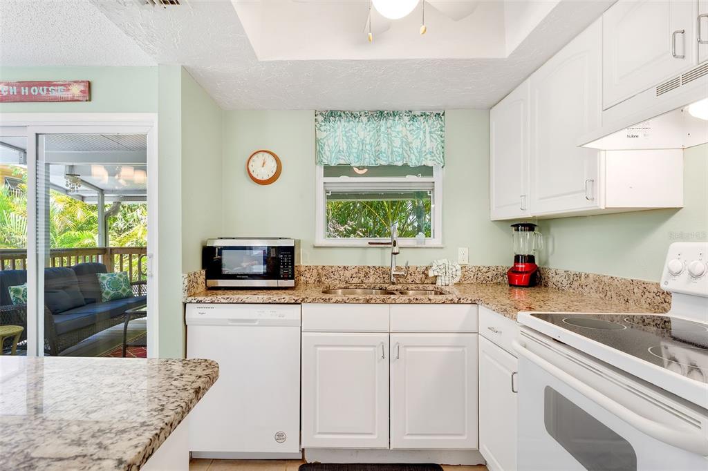412 80th Street Holmes Beach, FL 34217 - Photo 24 of 58 a kitchen with stainless steel appliances granite countertop a sink stove and cabinets
