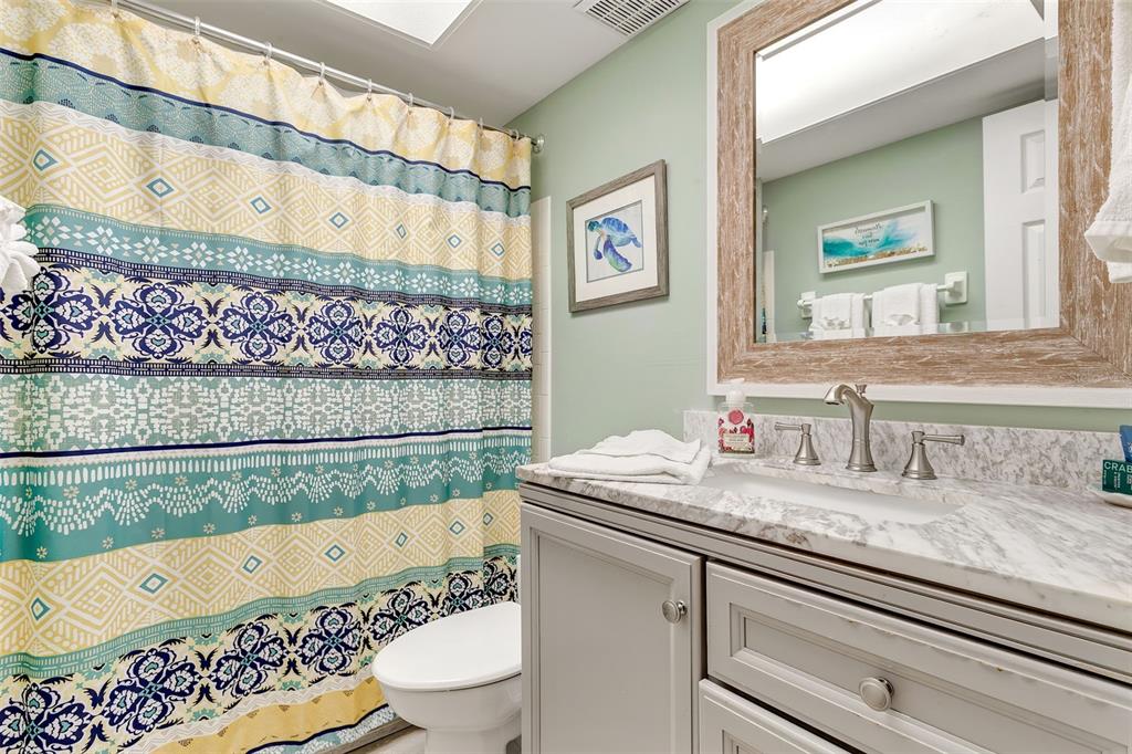 412 80th Street Holmes Beach, FL 34217 - Photo 29 of 58 a bathroom with a granite countertop sink and a mirror