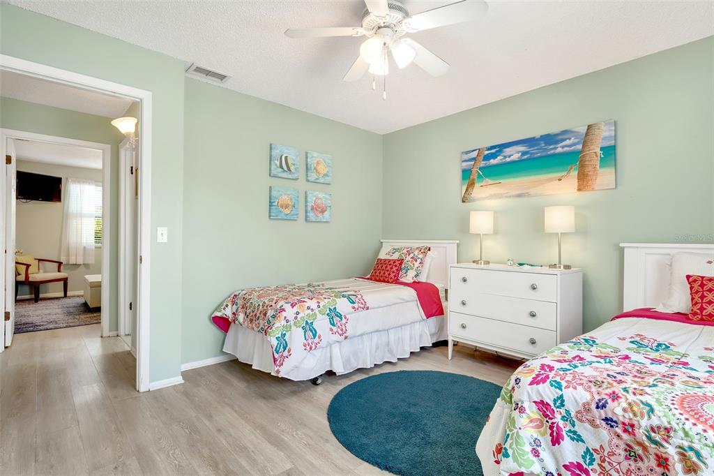 412 80th Street Holmes Beach, FL 34217 - Photo 32 of 58 a bedroom with two beds and a chandelier