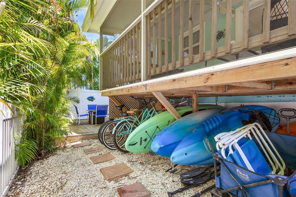 412 80th Street Holmes Beach, FL 34217 - Photo 45 of 58 a view of a patio with table and chairs with wooden fence and plants