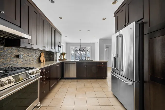 a kitchen with stainless steel appliances granite countertop a refrigerator and a stove top oven