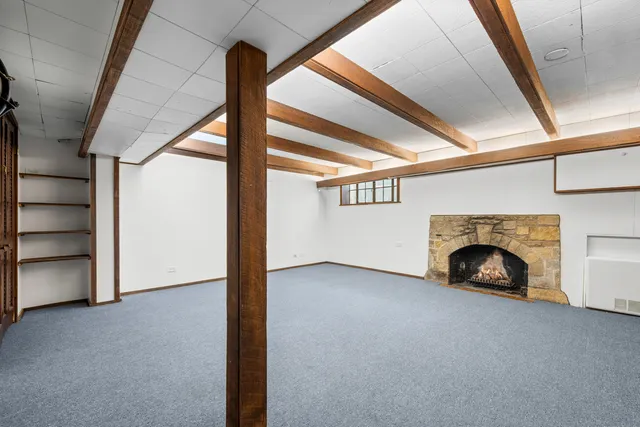 a view of an empty room with a fireplace and a window