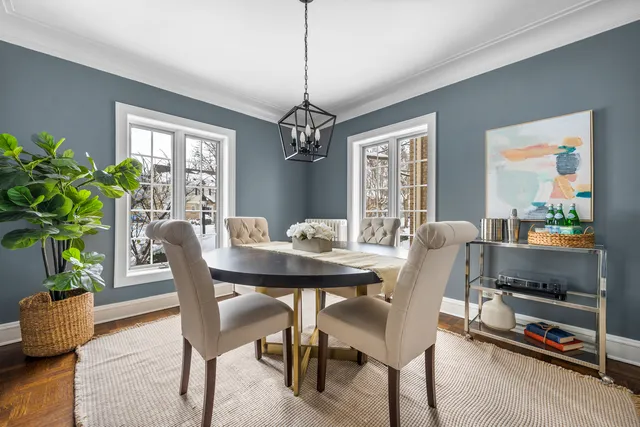 a dining room with furniture potted plants and wooden floor